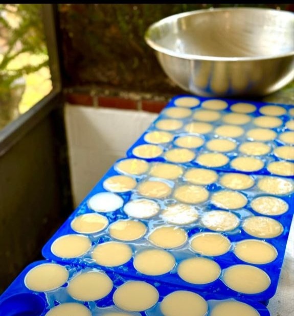 Fresh handmade soap poured into molds on a work table